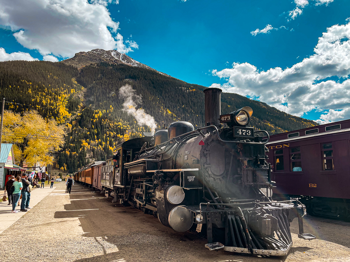 Durango train parked in the Silverton station with a colorful mountain in the backdrop