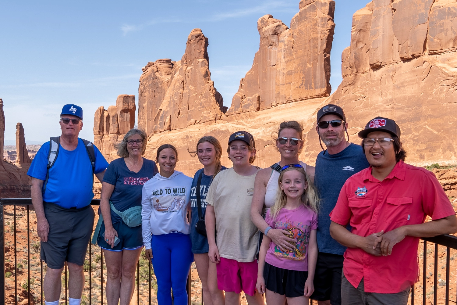 Family and guide standing in front of Red rock in Arches National Park - Moab, Utah