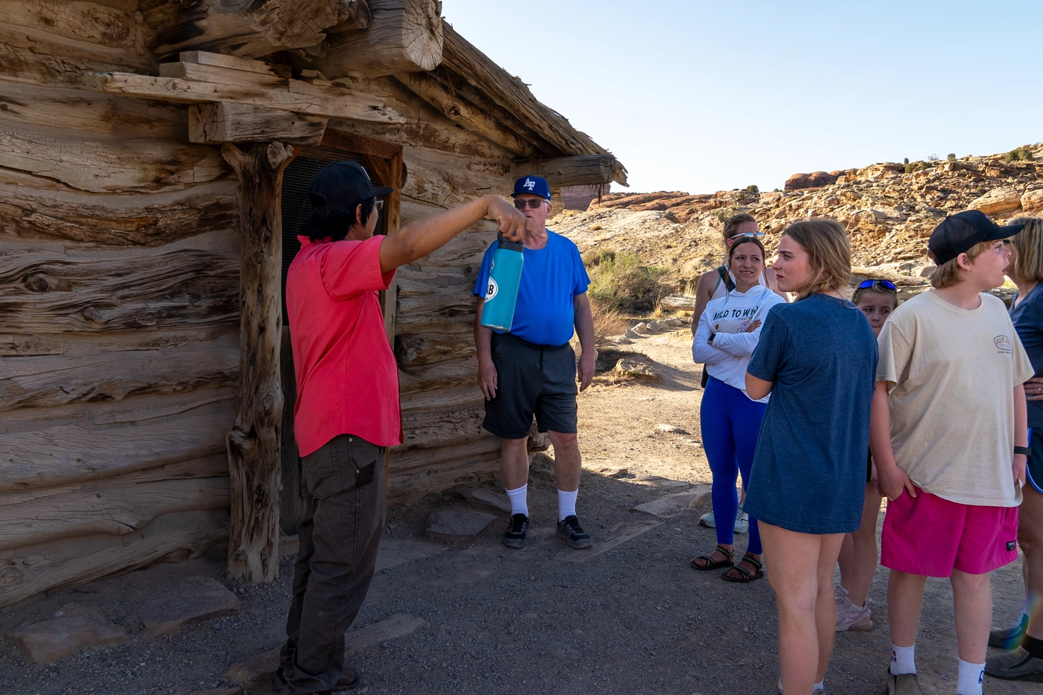 Family and guide standing in front of Wolf Ranch - Arches National Park - Moab, Utah