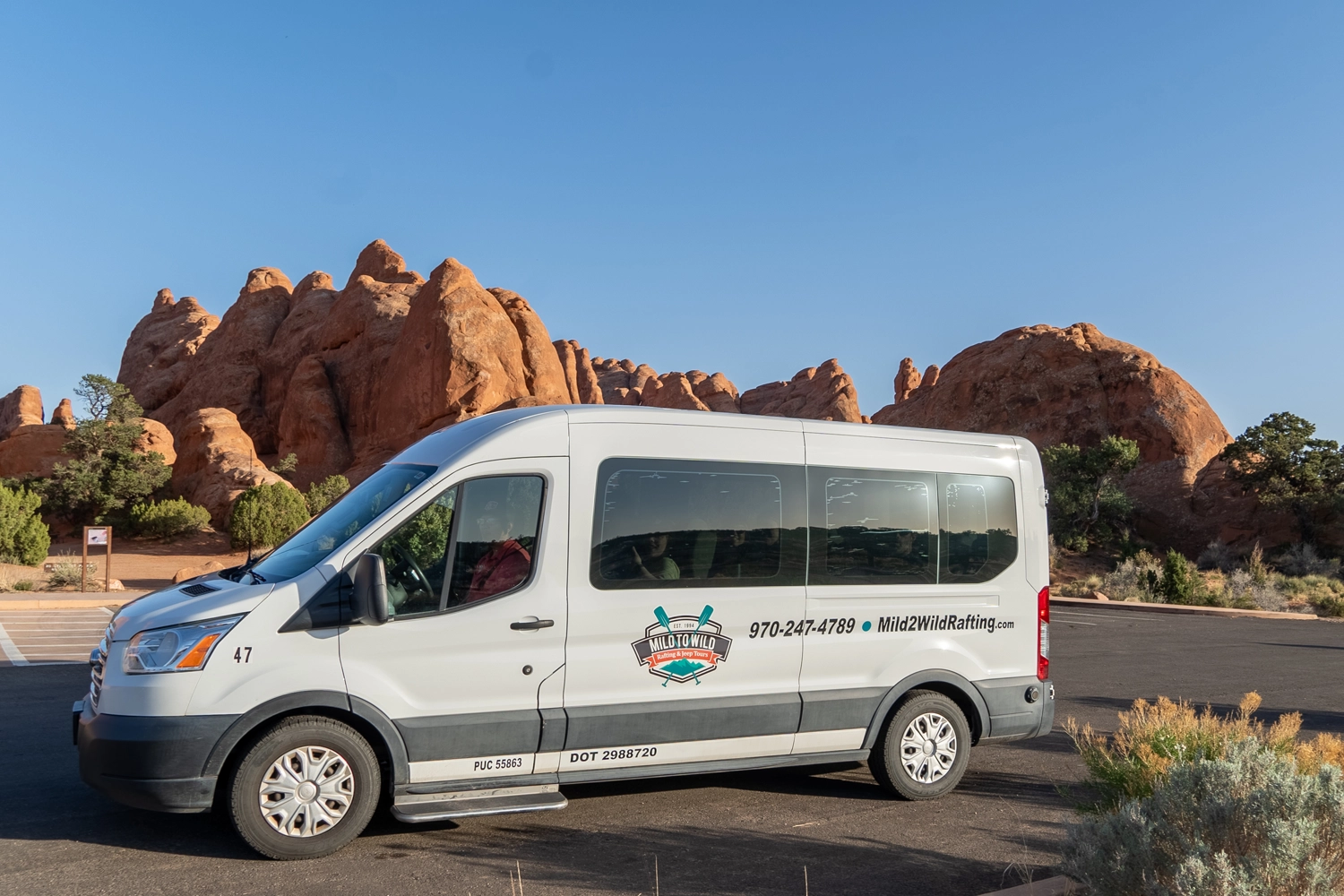 Mild to Wild transit Van in the parking lot in Arches National Park - Moab, Utah