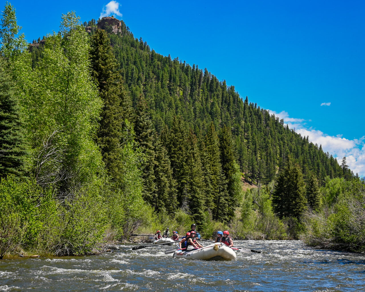 Rafting floating Upper Piedra River with mountain in the backdrop