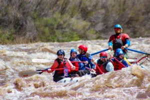 A raft full of paddlers rides the chocolaty waves of the Salt River in Arizona