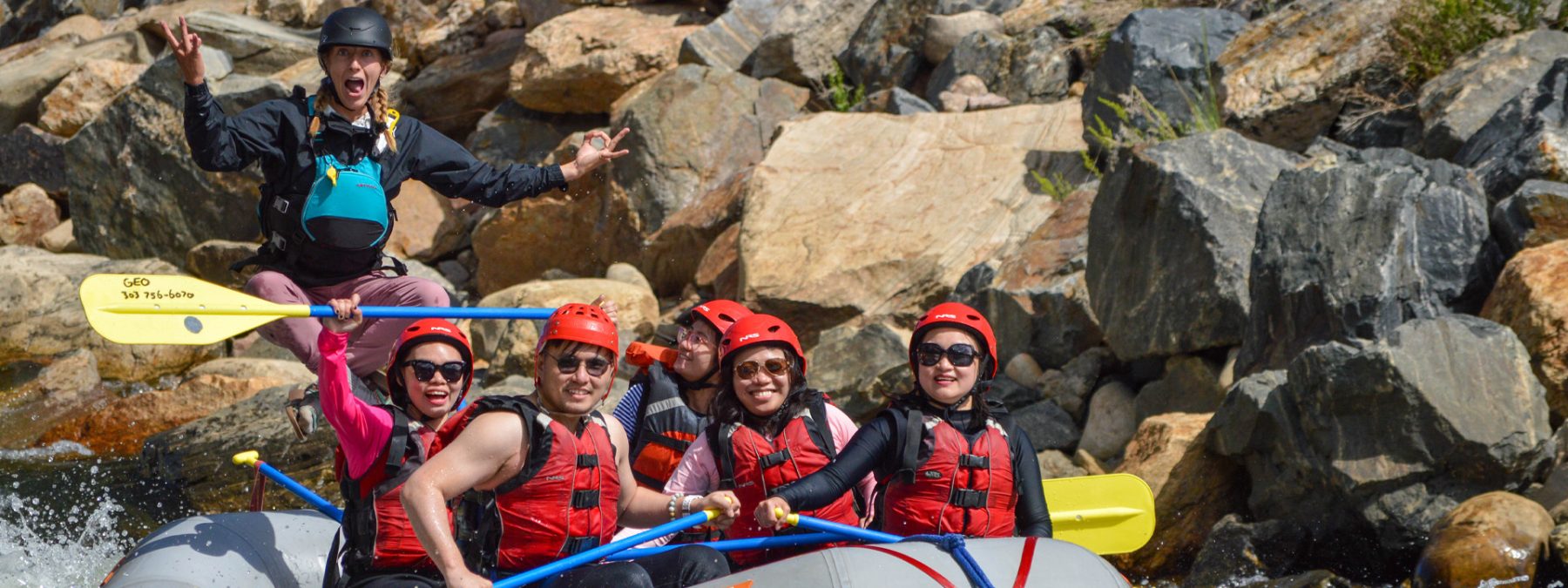 enthusiastic female river guide rafting with guests through Clear Creek - Denver, Colorado