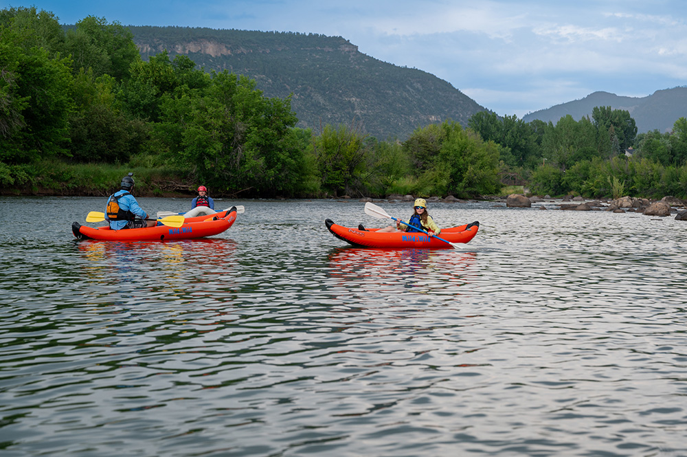 wide shot of inflatable kayakers on the lower animas river - durango colorado