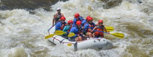 Raft full of smiling guests going through whitewater on Clear Creek in Idaho Springs, Colorado