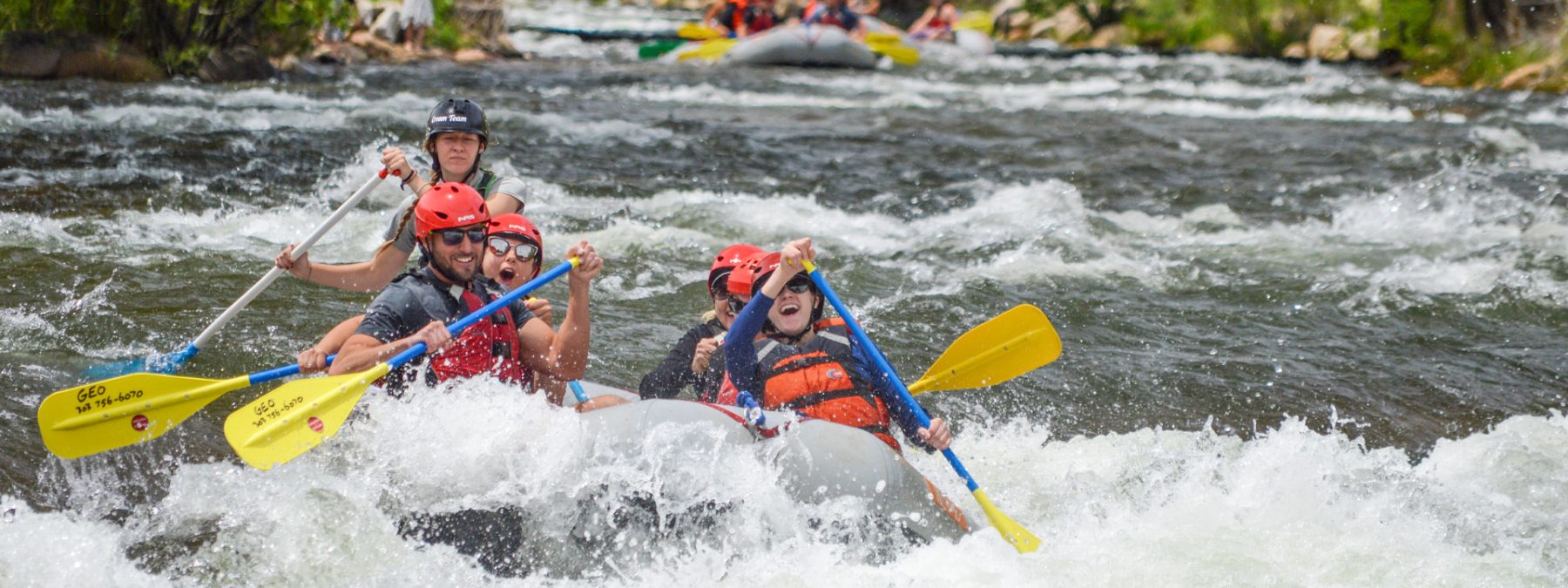 medium wide shot of raft paddling through whitewater rapids in clear creek - Idaho Springs Colorado near Denver