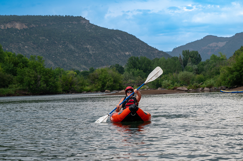 Inflatable kayaker woman paddling down the Lower Animas - Durango Colorado - Mild to wIld