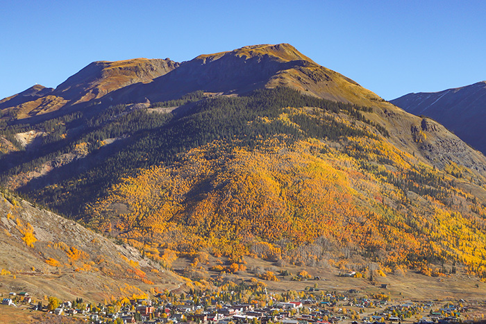 Wide landscape of the mountain above the town of Silverton covered in autumn colors