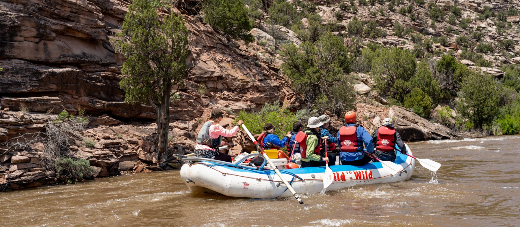 Shot from behind of rafts paddling down the Ponderosa section of the Dolores River