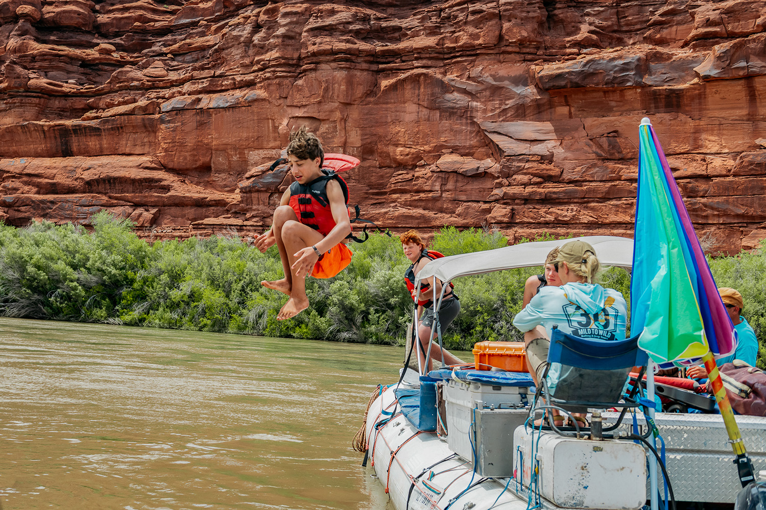 kid cannon balling off a raft into the Colorado River in Cataract Canyon - Mild to Wild