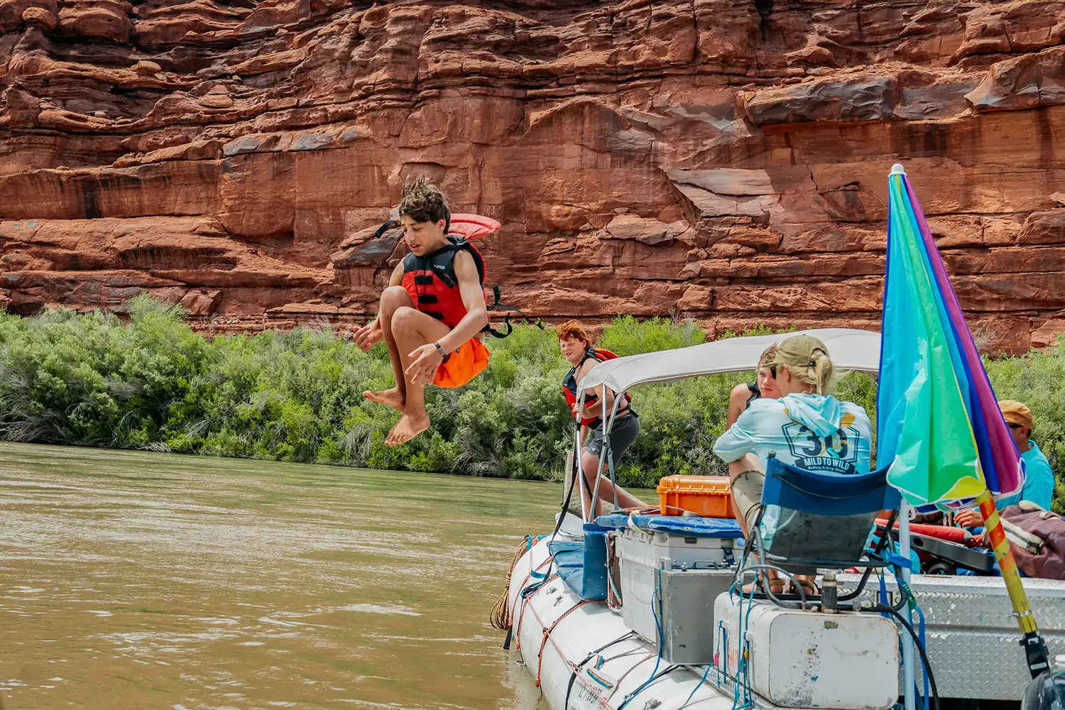 kid cannon balling off a raft into the Colorado River in Cataract Canyon - Mild to Wild