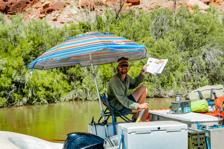 Guide holding up a river map on his boat in Cataract Canyon