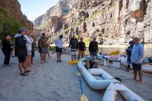 Guests on the beach in Gates of Lodore along the River - Guide instructing them on inflatable kayak commands