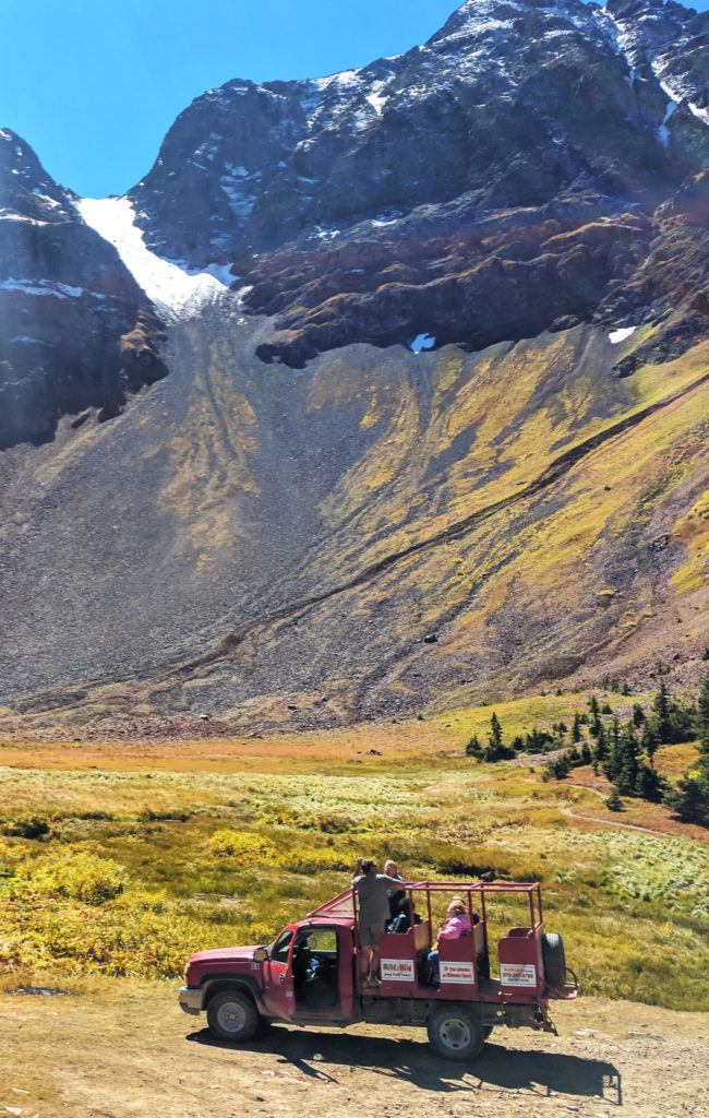 a jeep pictured in a valley in front of a mountain