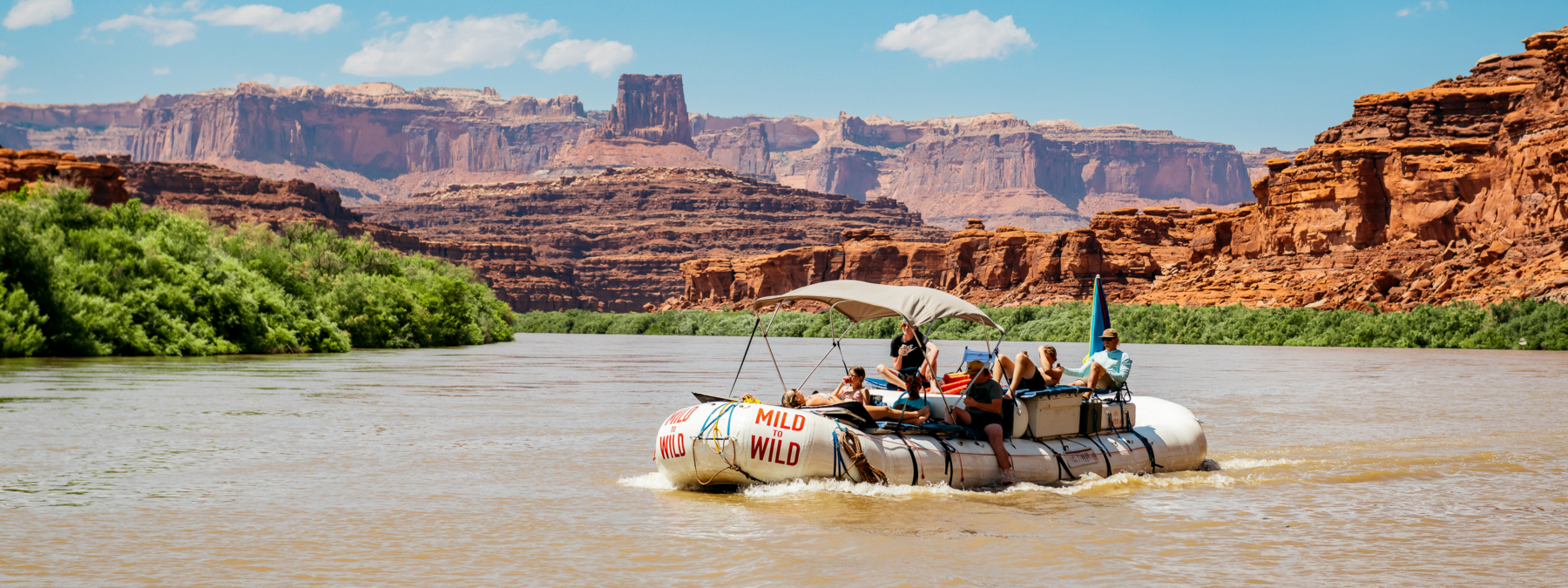 Wide shot of Cataract Canyon with a raft in the middle of the river - Mild to Wild