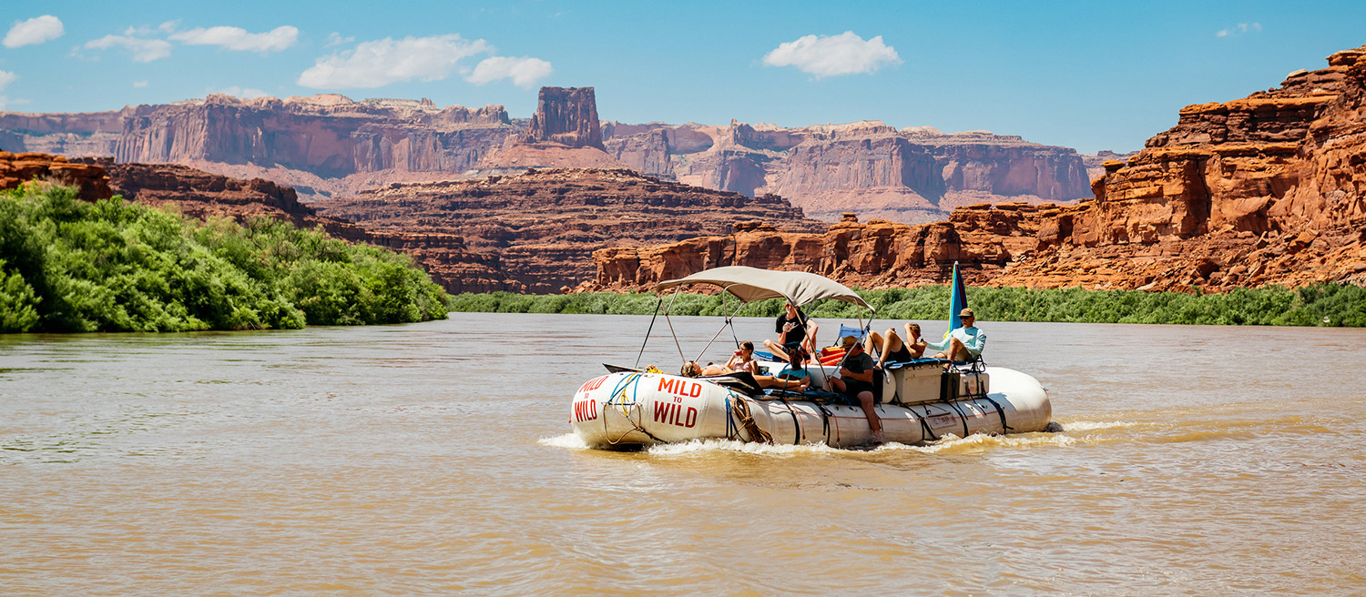 Wide shot of Cataract Canyon with a raft in the middle of the river - Mild to Wild