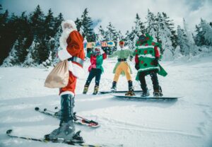 Santa skiing with guys in Christmas costumes