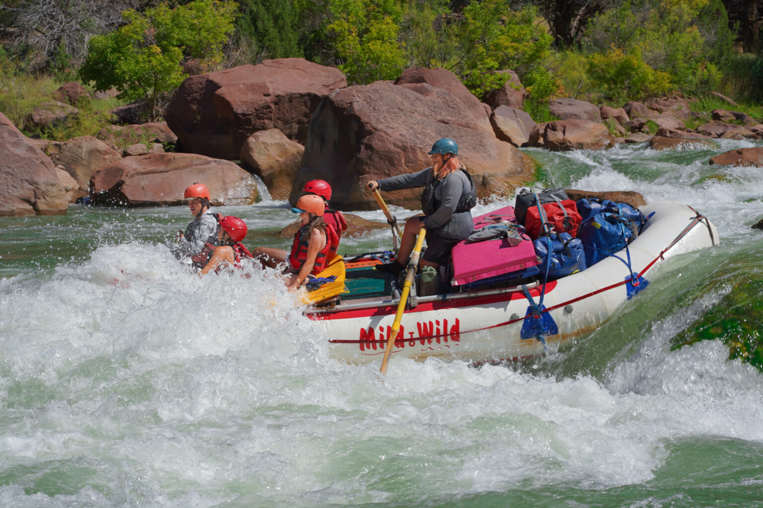 River guide Annie takes a boat of kids over Disaster Falls rapid in Gate of Lodore