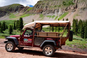 Close-up of Red Mild To Wild Jeep on the road with The La Plata Mountains in the background - Durango Jeep Tours