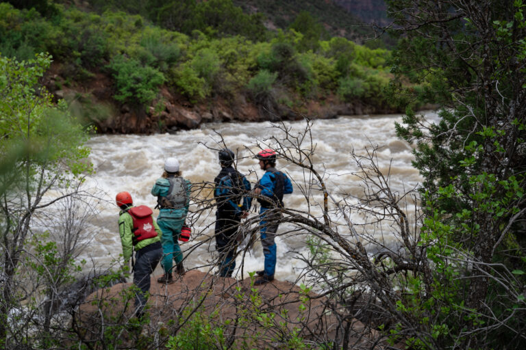 Guides on a rock Scouting Snaggletooth Rapid on The Dolores River