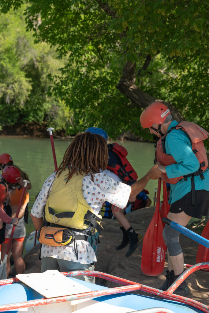 Durango Rafting on the Lower Animas River - Guide helping guest get on the raft