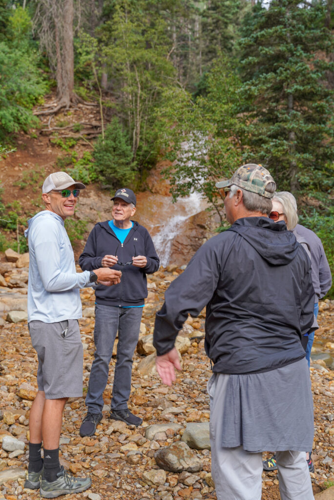 Group standing next to waterfall - Mild to Wild