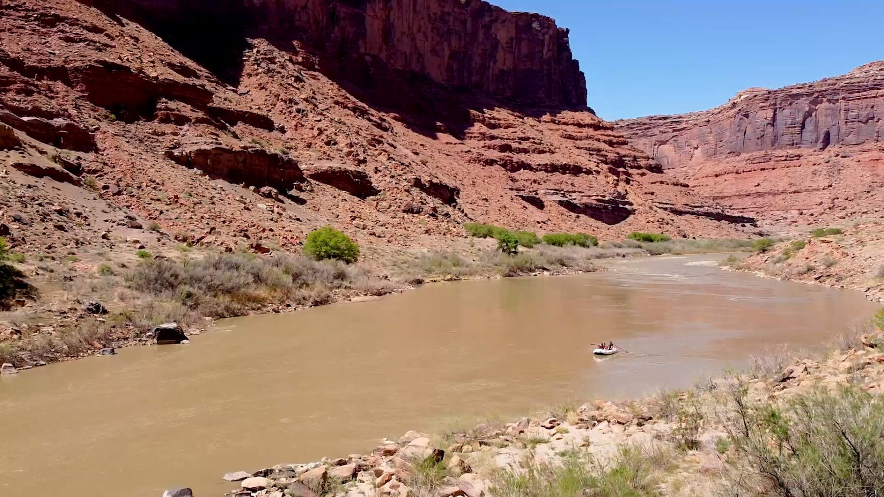 drone shot of red rock in moab with raft on the colorado river - mild to wild multi-day rafting trip