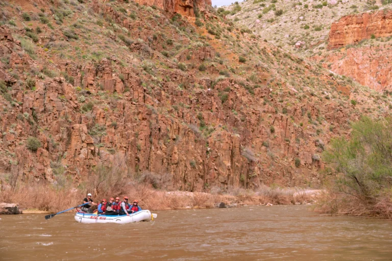 Boat floating through red canyon walls on the Salt River in Arizona - Mild to Wild