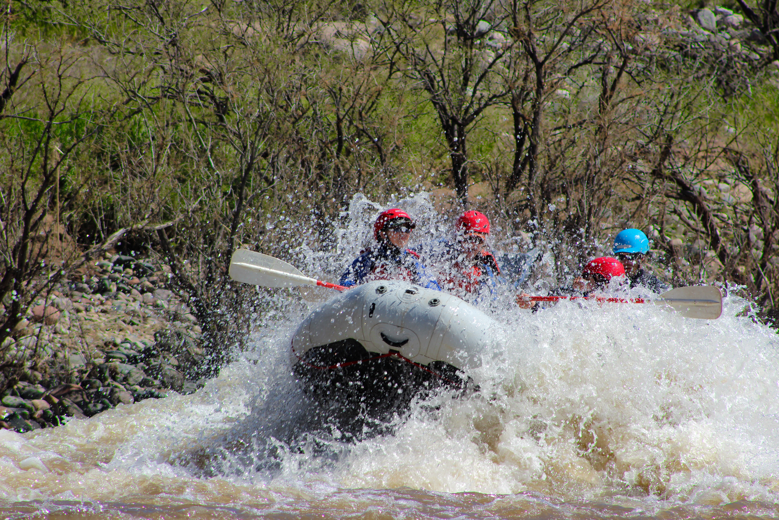 Raft hitting a rapid and splashing rafters on the Upper Salt River