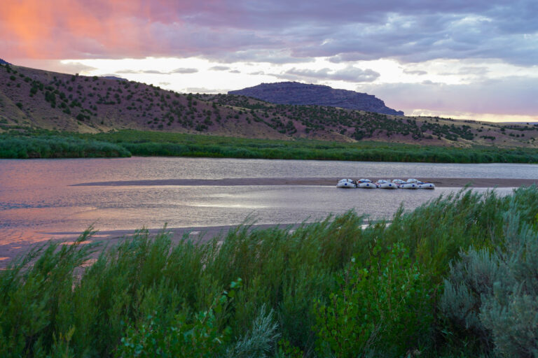 wide shot of mild to wild rafts parked on the beach in the evening - gates of lodore - donosaur national monument