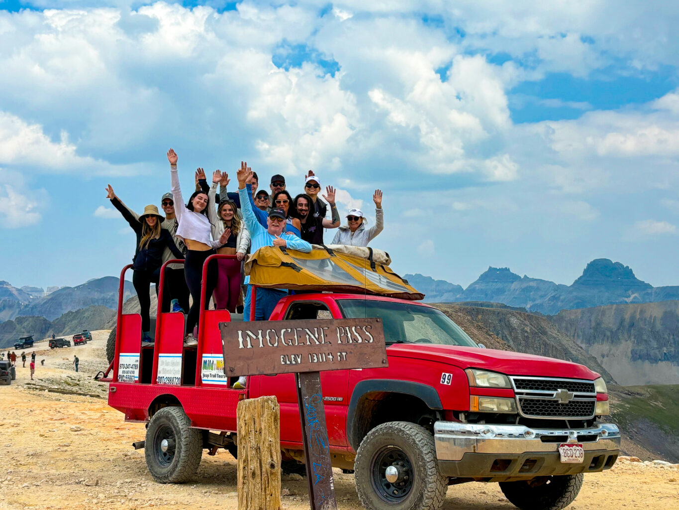 Group of people in a Jeep waving on Imogen Pass on a Telluride Jeep Tour