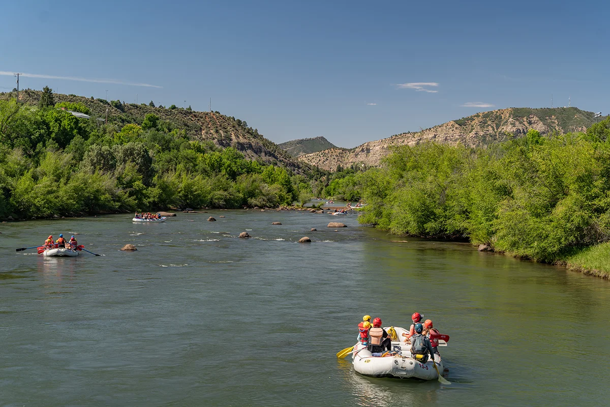 A group of multiple rafts heading down a river