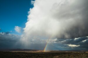 Rain clouds with a rainbow over the desert Moab landscape