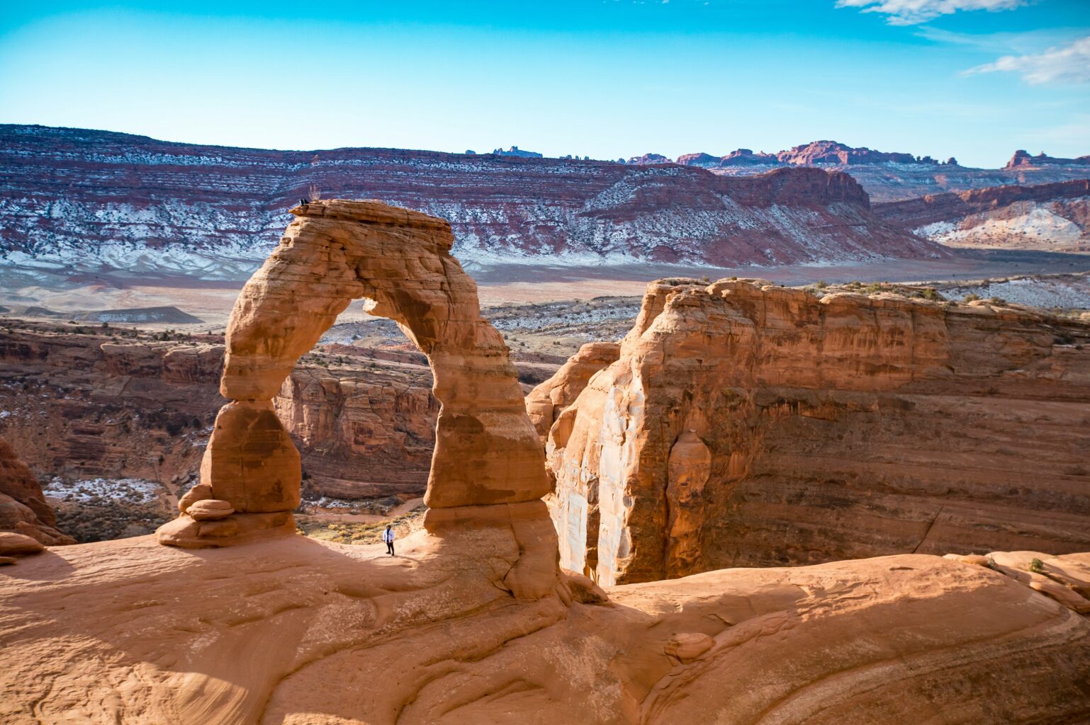 Delicate Arch with morning light and snow in the background