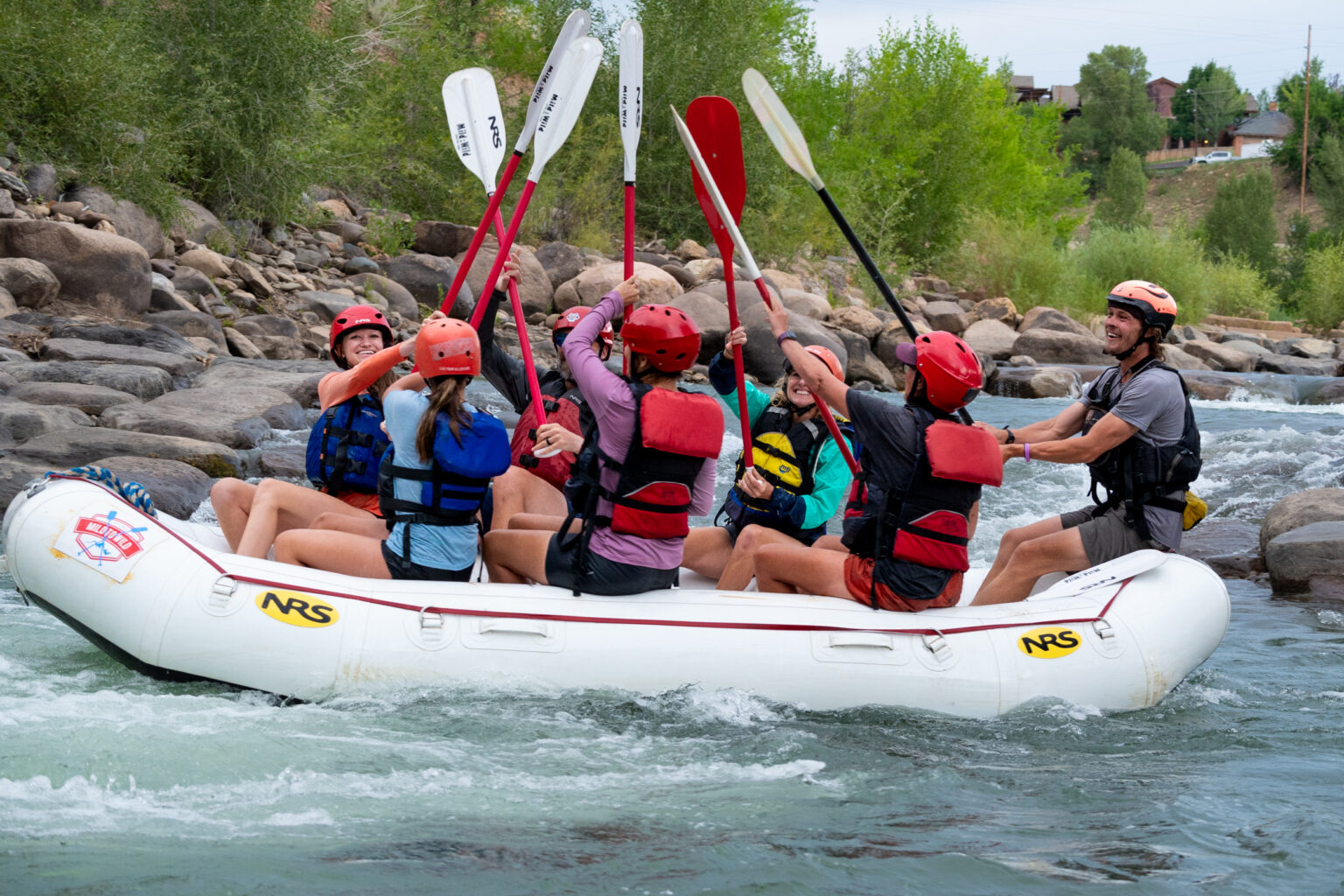 Group in a raft putting their paddles together on the Lower Animas for Raft for Hope