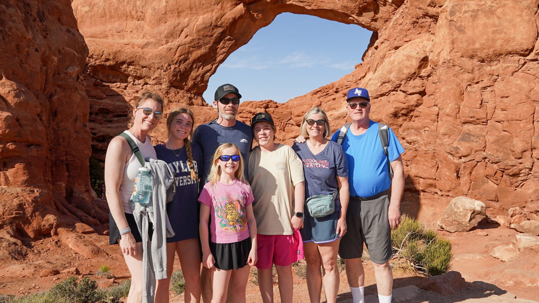 family standing in front of an arch in Arches National Park - Moab, Utah