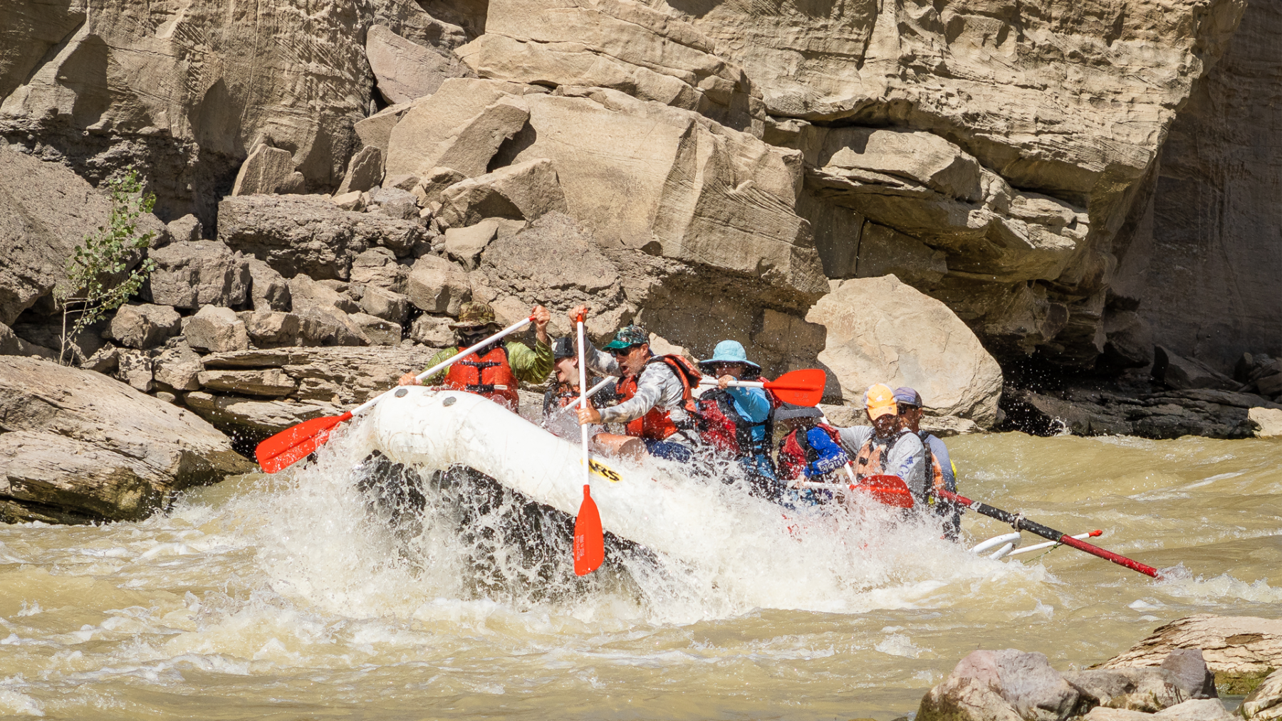 medium shot of raft paddling through whitewater in Desolation Canyon