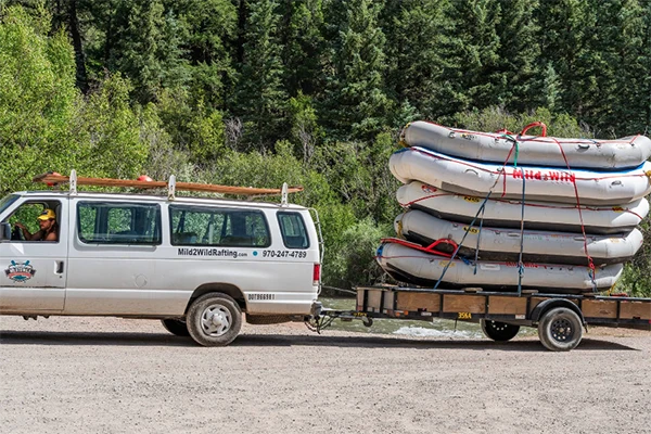 a van tows a stack of rafts to the Telluride outpost