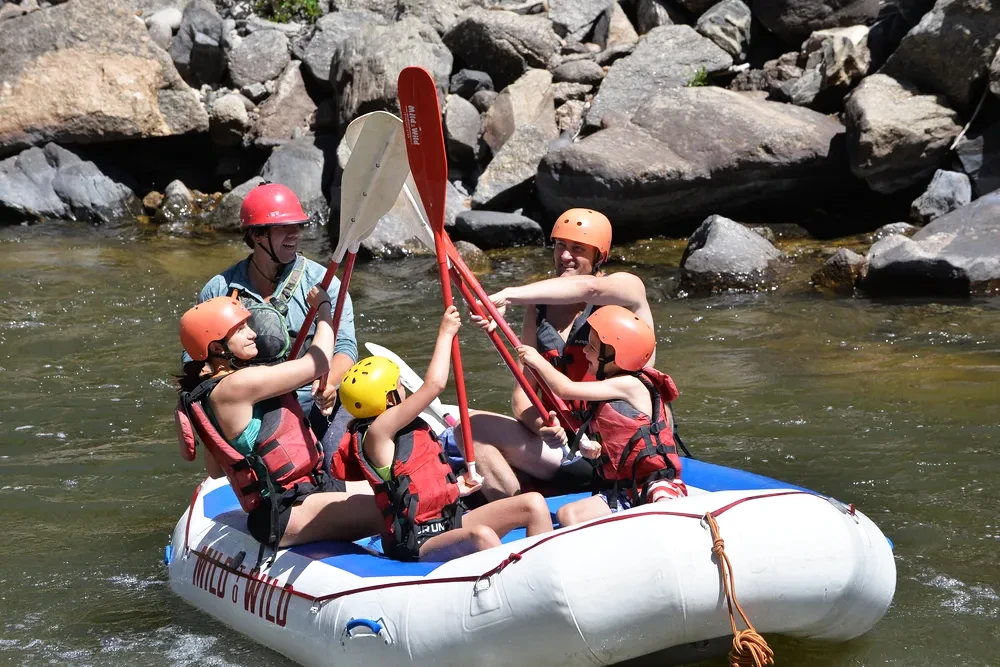 Guests paddle fiving after Sidel's Rapid on the Arkansas River