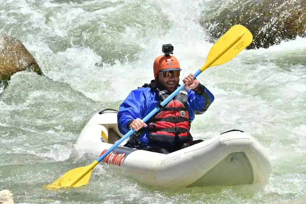 Inflatable kayaker smiliing face with Siedel's Suckhole in the background