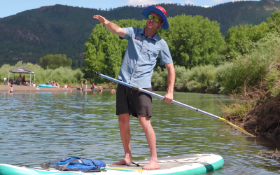 close up of guide on paddle board pointing about to give SUP tips - mild to wild