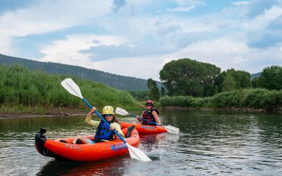 Wide shot of two people in Inflatable Kayaks on the Lower Animas River - Scenicm ountain background